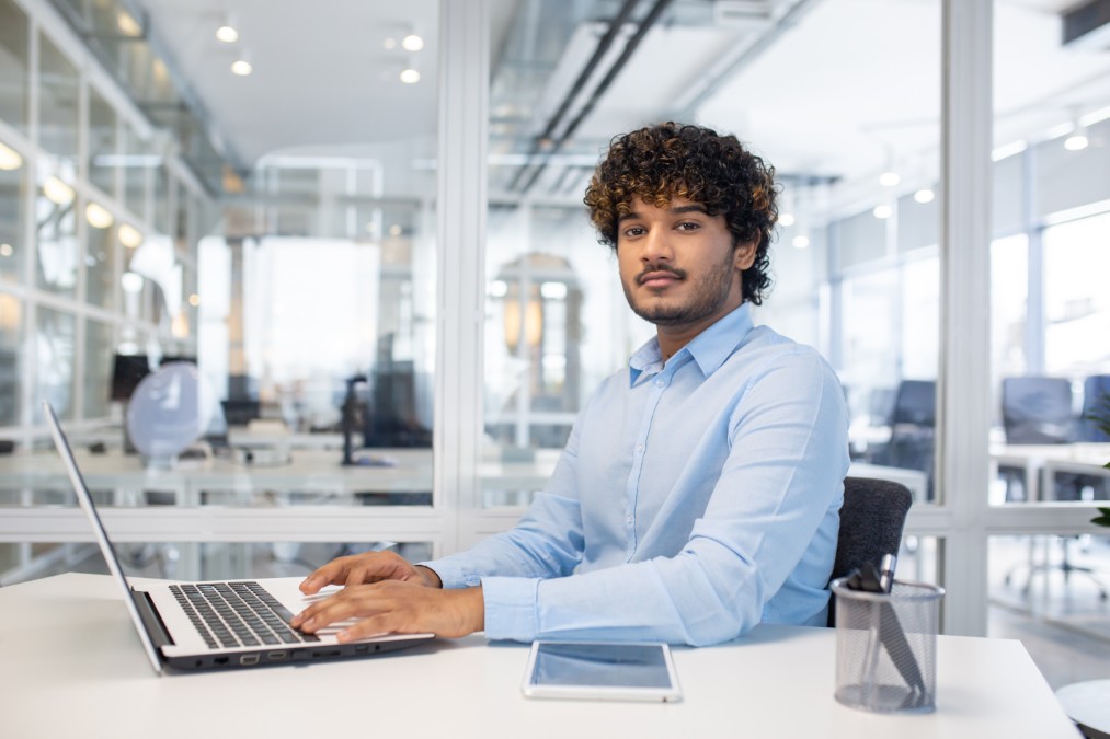 Un consultant freelance travaillant sur son ordinateur dans un espace moderne, illustrant l'autonomie offerte par le portage salarial Lille.
